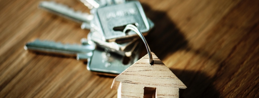 A ring of keys with a wooden house keychain
