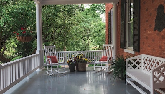 front porch with rocking chairs and bench